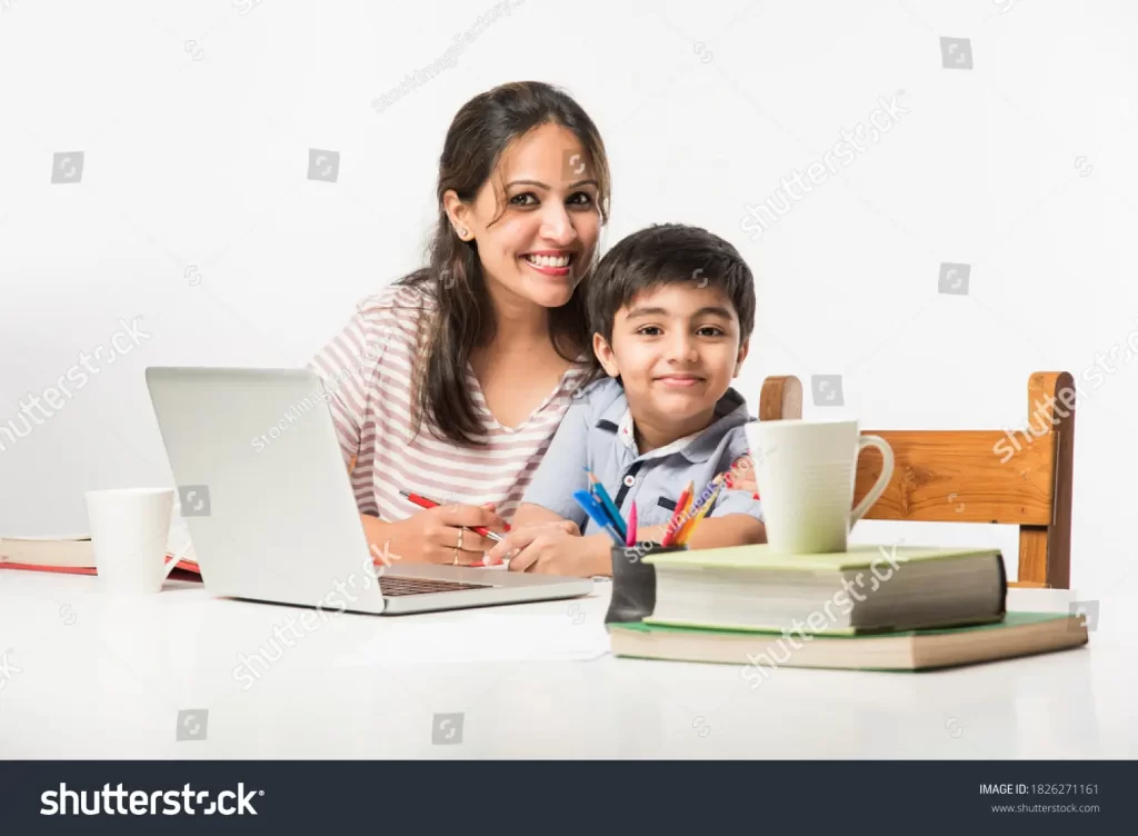 Cute Indian boy doing homework with mother